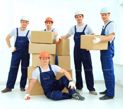 Movers carrying furniture through a Hackney flat with narrow stair access
