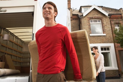 Moving crew loading furniture into a van on a Hackney street
