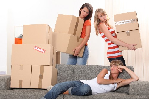 Moving staff wearing PPE while carrying furniture safely